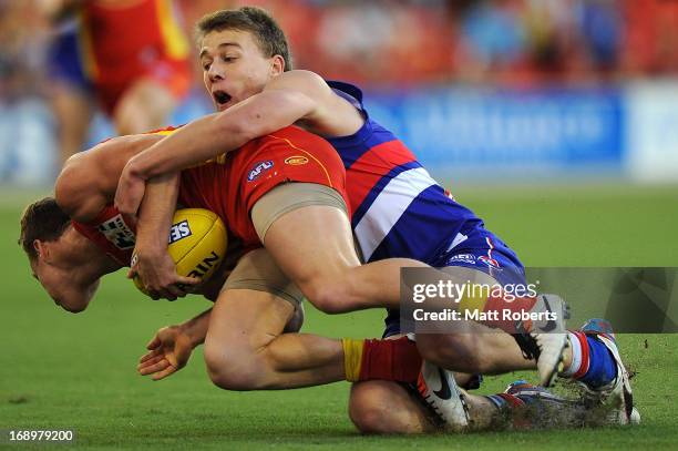 Brandon Matera of the Suns is tackled by Jack Macrae of the Bulldogs during the round eight AFL match between the Gold Coast Suns and the Western...