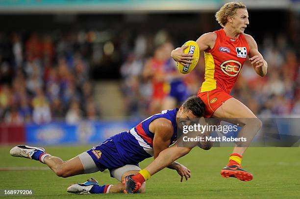 Trent McKenzie of the Suns is tackled by Daniel Gainsiracusa of the Bulldogs during the round eight AFL match between the Gold Coast Suns and the...