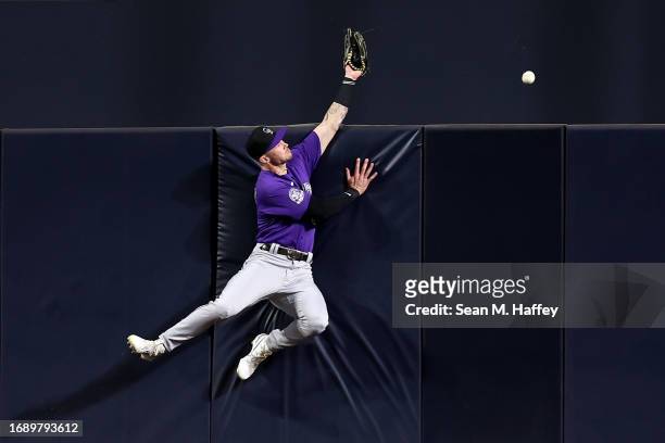 Brenton Doyle of the Colorado Rockies is unable to catch a two run homerun hit by Garrett Cooper of the San Diego Padres during the second inning of...