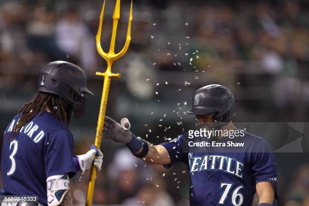 Jose Caballero of the Seattle Mariners is congratulated by J.P. Crawford after he hit a two-run home run against the Oakland Athletics in the fourth...