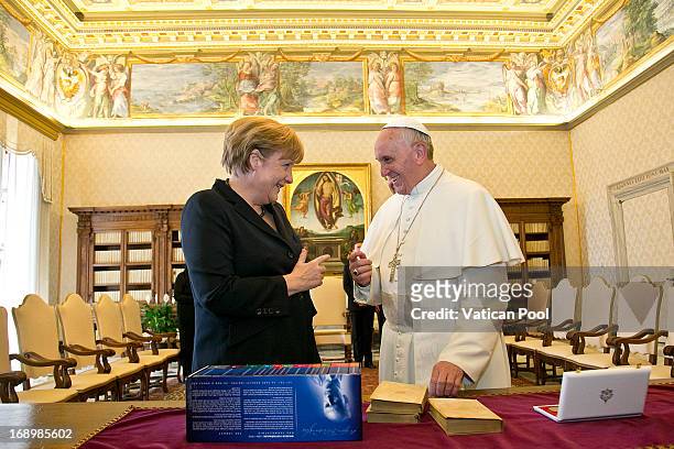 Chancellor of Germany Angela Merkel exchanges gifts with Pope Francis during an audience at his private library on May 18, 2013 in Vatican City,...