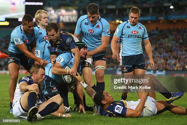 Berrick Barnes of the Waratahs is congratulated by his team mates after scoring a try during the round 14 Super Rugby match between the Waratahs and...