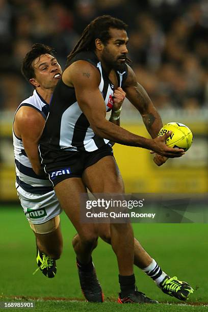 Harry O'Brien of the Magpies handballs whilst being tackled by Allen Christensen of the Cats during the round eight AFL match between the Collingwood...