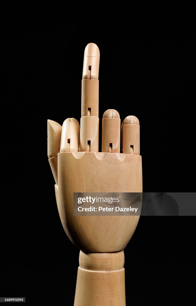 Wooden hand showing rude finger