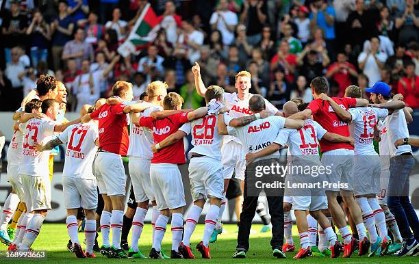 Players and staff of Augsburg celebrate remaining in the first division of the German soccer league after the Bundesliga match between FC Augsburg...