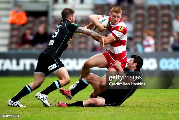 Jack Hughes of Wigan is tackled by Will Lovell and Shane Grady of London Broncos during the Super League match between London Broncos and Wigan...