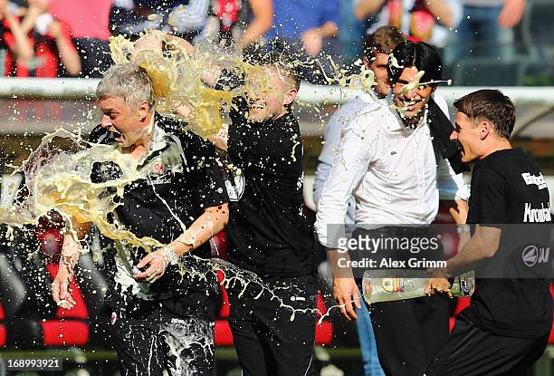 Head coach Armin Veh of Frankfurt is showered with beer by Marc Stendera and Stefano Celozzi after the Bundesliga match between Eintracht Frankfurt...