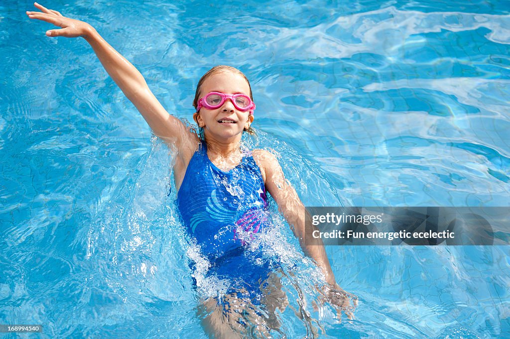 Girl swimming backstroke in pool