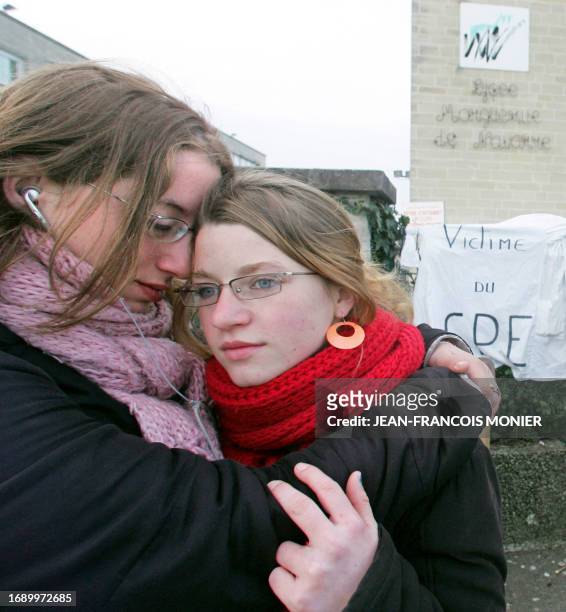 Two high school students embrace each other as they get in their school, 05 April 2006 in the western French town of Alencon, the day it reopened...