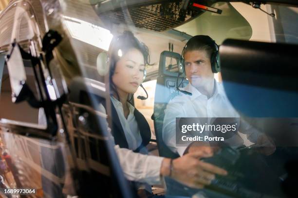 flight instructor teaching a trainee pilot how to fly a helicopter - helicopter window stock pictures, royalty-free photos & images
