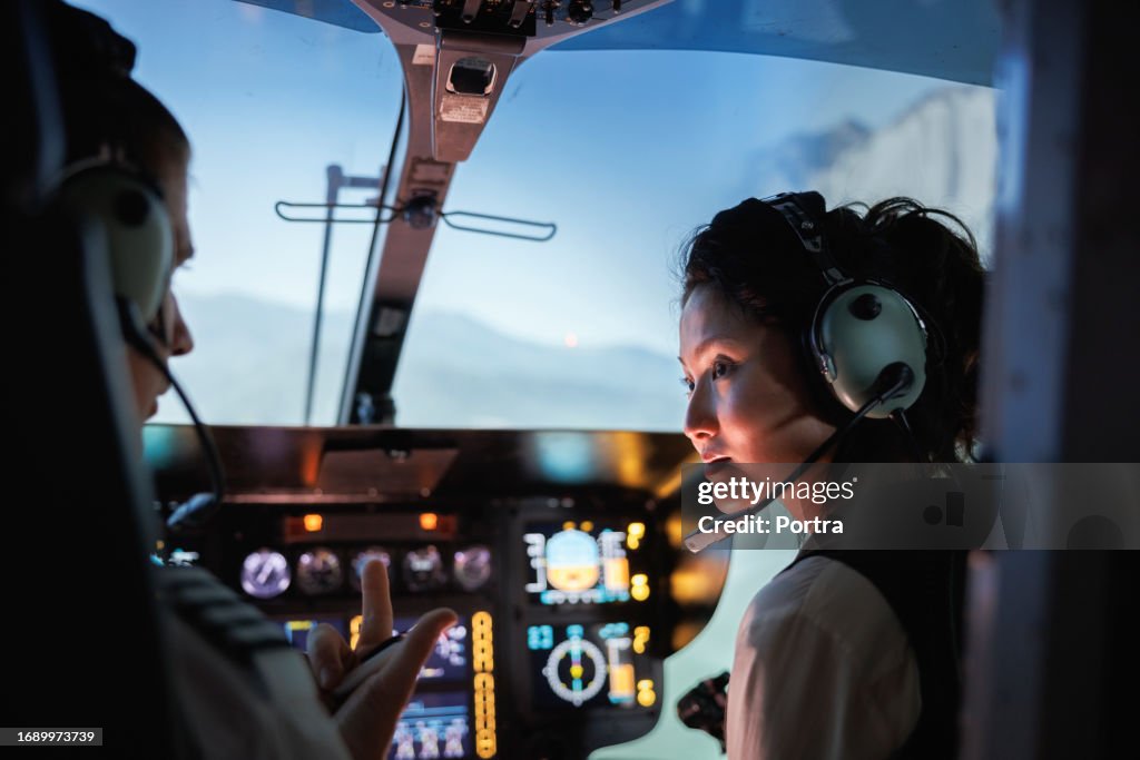 Female helicopter pilot talking with a another pilot before takeoff.