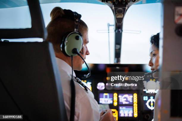 helicopter pilots talking together. - airline cockpit stock pictures, royalty-free photos & images