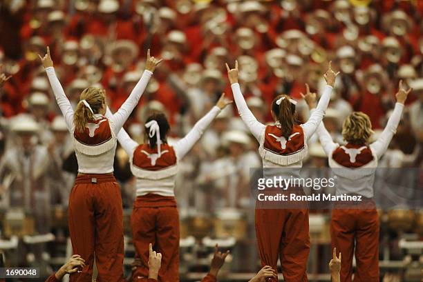 Female cheerleaders of the Texas Longhorns stand on the shoulders of male cheerleaders and flash the "Hook 'Em Horns" sign after the victory over the...