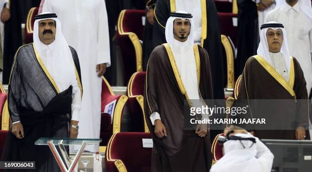 Qatar's Emir Sheikh Hamad bin Khalifa al-Thani stands with his son Sheikh Jassim bin Hamad al-Thani and new Asian Football Confederation President...