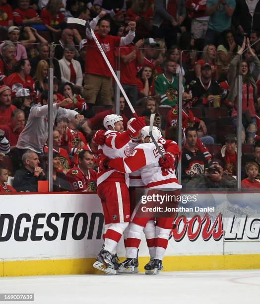 Johan Franzen, Justin Abdelkader and Pavel Datsyuk of the Detroit Red Wings celebrate Franzens' third period goal against the Chicago Blackhawks in...