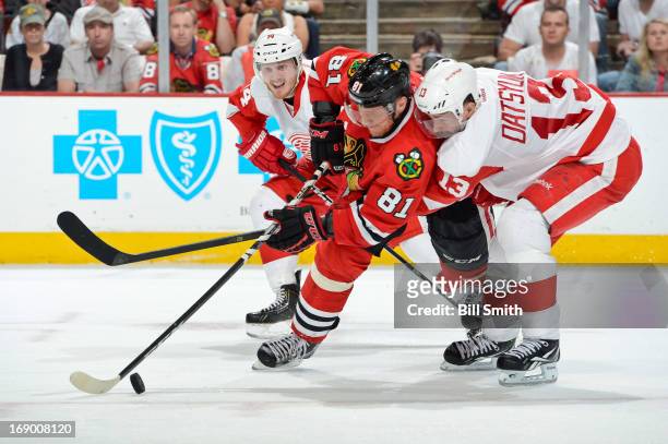 Marian Hossa of the Chicago Blackhawks and Pavel Datsyuk of the Detroit Red Wings battle for the puck as Gustav Nyquist of the Red Wings watches from...