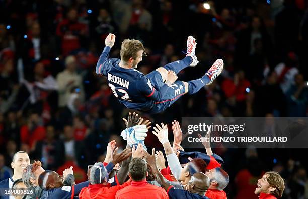 Paris Saint-Germain's English midfielder David Beckham is thrown into the air after the French L1 football match between Paris St Germain and Brest...