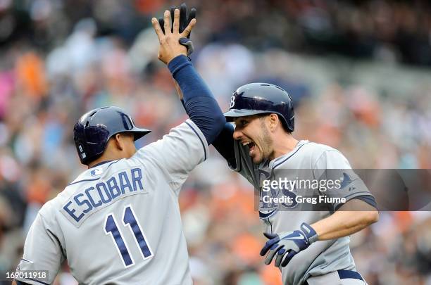 Matt Joyce of the Tampa Bay Rays celebrates with Yunel Escobar after hitting a home run in the third inning against the Baltimore Orioles at Oriole...
