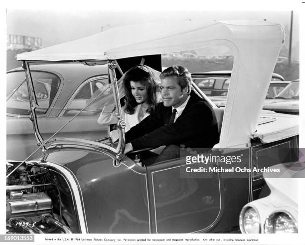Pamela Tiffin and Doug McClure wait impatiently to race his custom hotrod in a scene from the film 'The Lively Set', 1964.