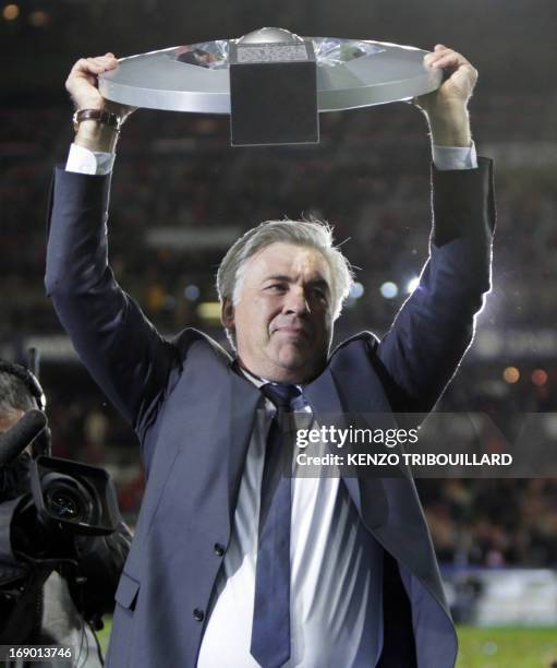 Paris Saint-Germain's coach Carlo Ancelotti holds up the league trophy during the ceremony for the French league title after the French L1 football...