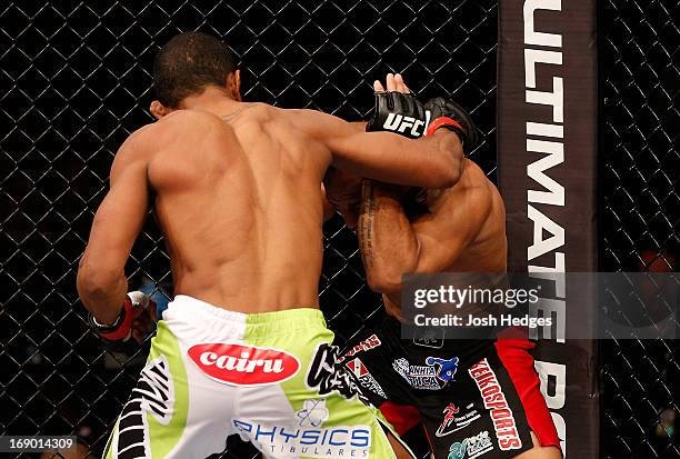 Yuri Alcantara punches Iliarde Santos in their bantamweight bout during the UFC on FX event on May 18, 2013 at Arena Jaragua in Jaragua do Sul, Santa...