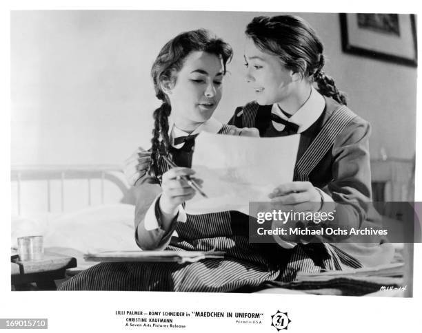 Christine Kaufmann and Romy Schneider reading a paper together in a scene from the film 'Maedchen In Uniform', 1958.