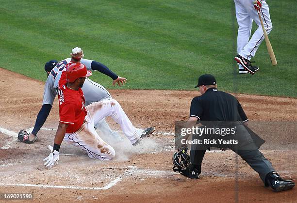 Home plate umpire Mike Muchlinski looks on as Elvis Andrus of the Texas Rangers beats the throw to score against Anibal Sanchez of the Detroit Tigers...