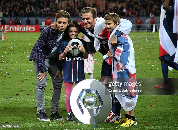 David Beckham and his sons Brooklyn Beckham, Cruz Beckham and Romeo Beckham pose on the field during the celebration of PSG's french championship...