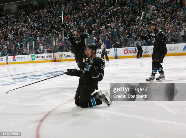 Logan Couture, Brent Burns and Joe Thornton of the San Jose Sharks celebrate Couture's game-winning overtime goal against the Los Angeles Kings in...