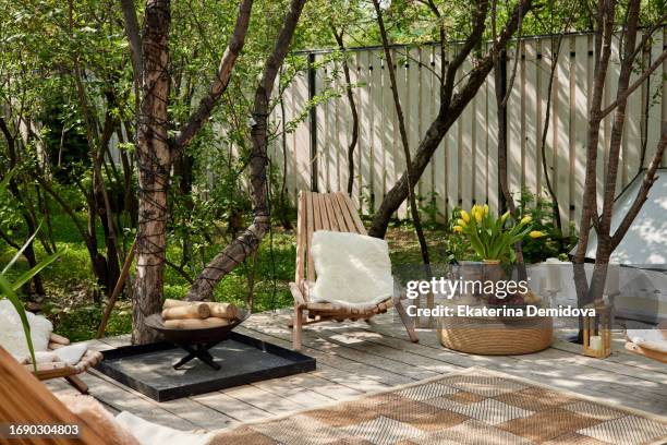 neat and tidy terrace with easy chairs firewood placed on daylight - wooded backyard stock pictures, royalty-free photos & images