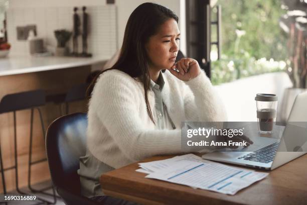 financial worries: woman at dining table with bill and computer - anna graves stock pictures, royalty-free photos & images
