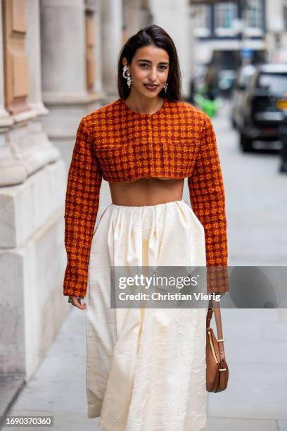 Bettina Looney wears cropped checkered top, creme white skirt, bag outside Emilia Wickstead during London Fashion Week September 2023 at the on...