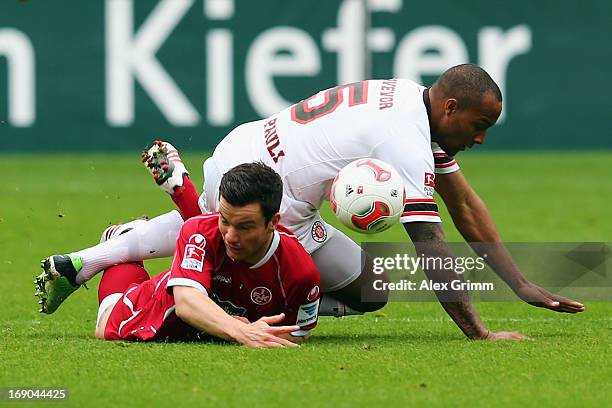 Alexander Baumjohann of Kaiserslautern is challenged by Christopher Avevor of St. Pauli during the Second Bundesliga match between 1. FC...