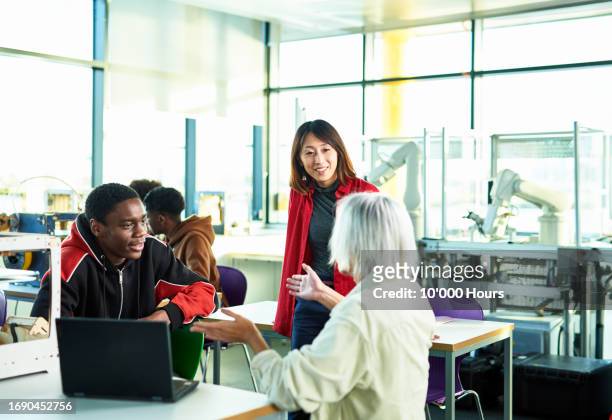 enthusiastic student talking to college tutor explaining project and gesturing - chinese tutor study stock-fotos und bilder