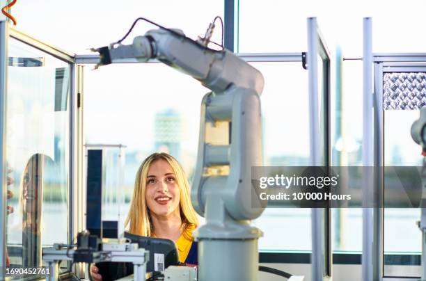 transgender student in workshop with robotic arm at technical college - orthographic symbol stock pictures, royalty-free photos & images