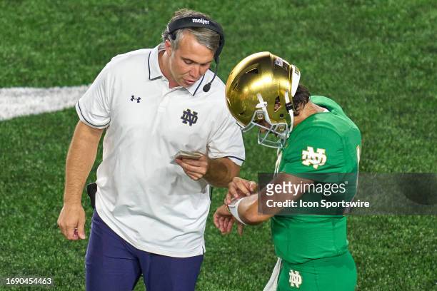 Notre Dame Fighting Irish quarterback Sam Hartman talks with quarterbacks coach Gino Guidugli in action during a football game between the Notre Dame...