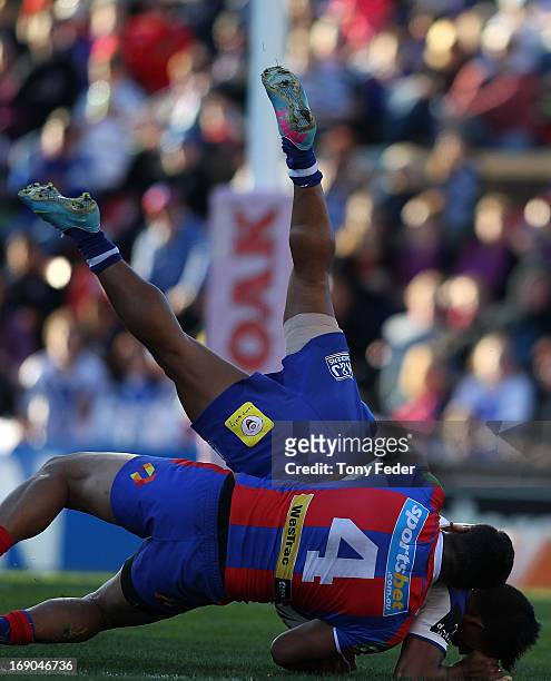 Ben Barba of the Bulldogs is tackled by Joey Leilua of the Knights during the round 10 NRL match between the Newcastle Knights and the Canterbury...