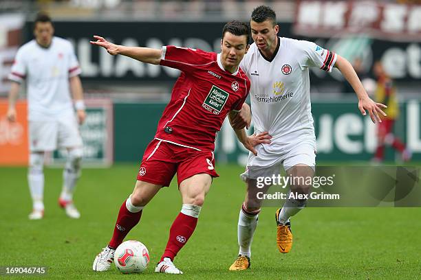 Alexander Baumjohann of Kaiserslautern is challenged by Dennis Daube of St. Pauli during the Second Bundesliga match between 1. FC Kaiserslautern and...