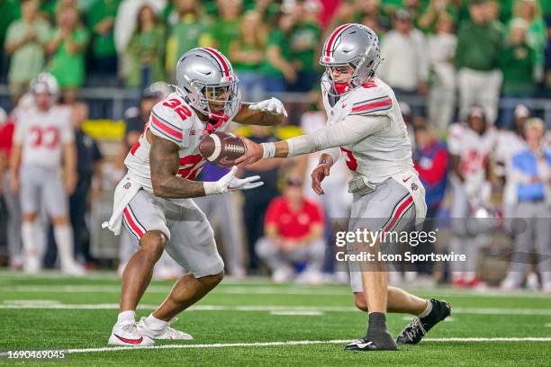 Ohio State Buckeyes quarterback Kyle McCord hands the football to Ohio State Buckeyes running back TreVeyon Henderson in action during a football...