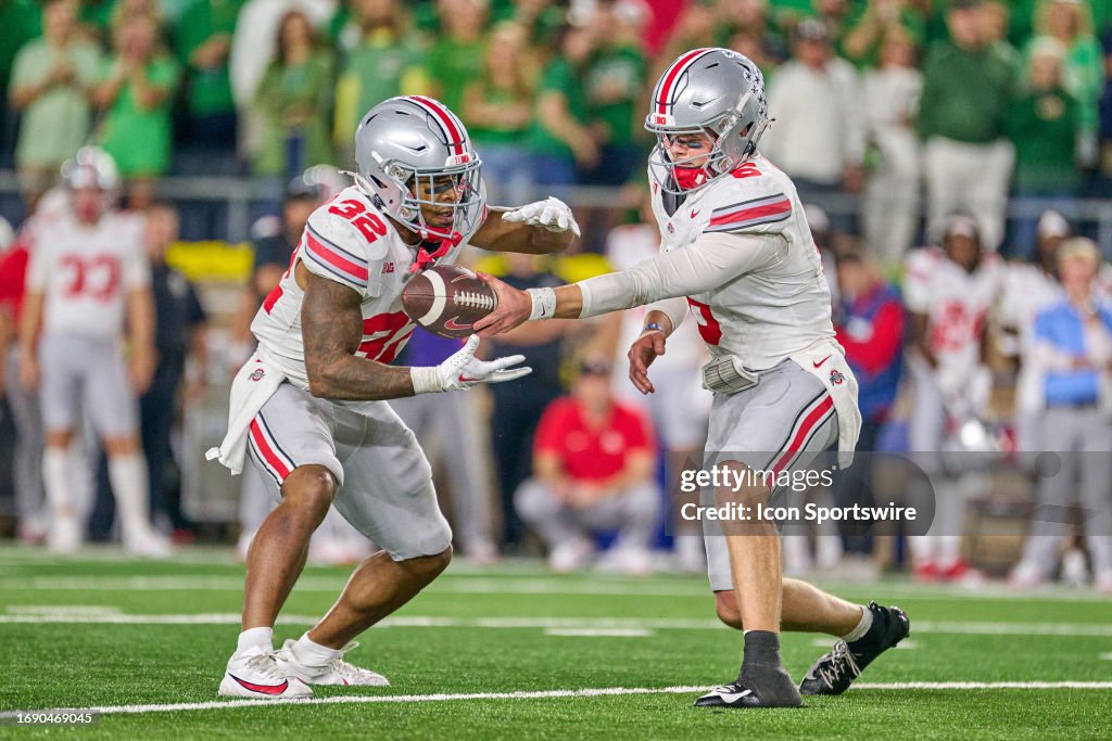 Ohio State Buckeyes quarterback Kyle McCord hands the football to
