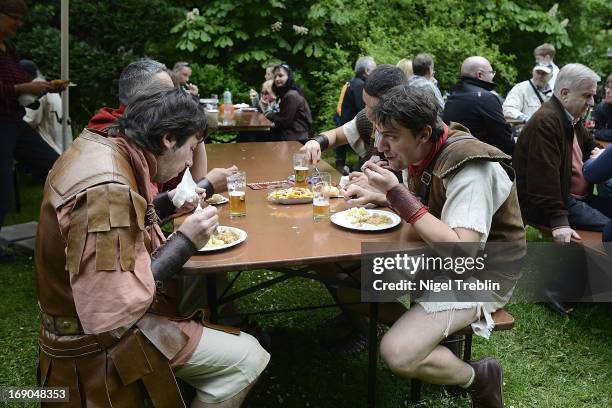 Actors dressed as Roman soldiers have lunch in a beer garden during a commemoration of the Battle of Teutoburg Forest at the Kalkriese Museum and...