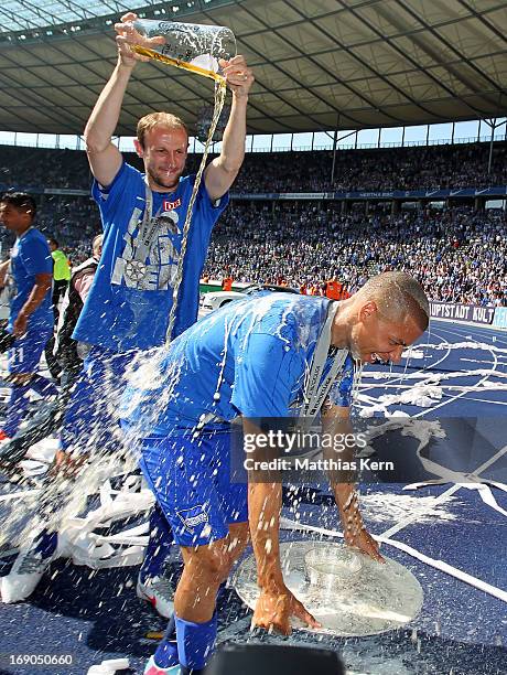 Marcel Ndjeng of Berlin gets a beer shower after winning the championship after the Second Bundesliga match between Hertha BSC Berlin and FC Energie...