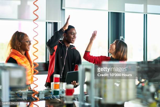 product design student doing high five with tutor in workshop - orthographic symbol stock pictures, royalty-free photos & images