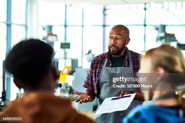 further education tutor talking to students in college workshop - education occupation stock pictures, royalty-free photos & images