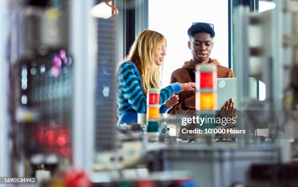 two young students working in technical lab with computer with conveyor belt,  planning, strategy, innovation - poly stock pictures, royalty-free photos & images