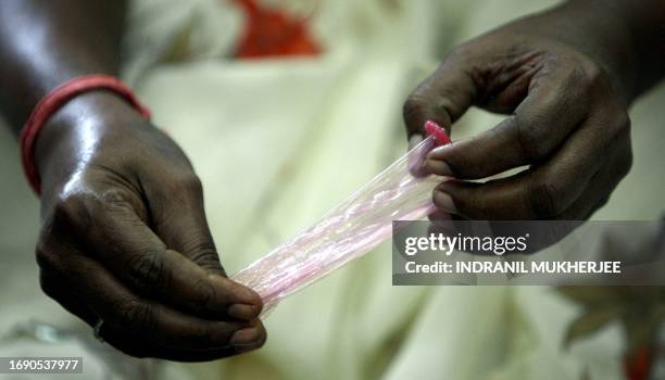 An Indian sex worker demonstrates how to dispose a used condom during a behavioural change communication session at the Social Activities Integration...