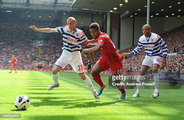 Jordan Ibe of Liverpool competes with Michael Harriman and Loic Remy of Queens Park Rangers during the Barclays Premier League match between...