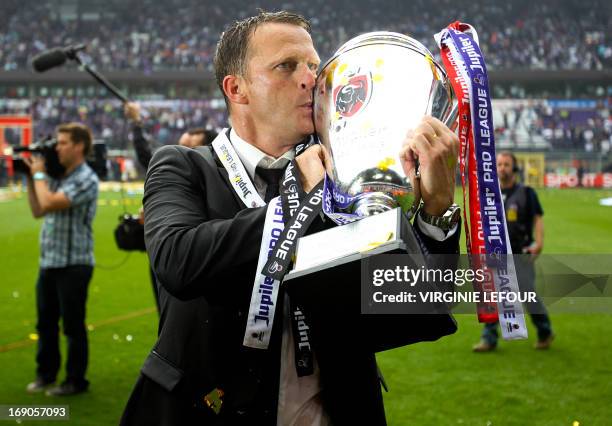 Anderlecht's Dutch head coach John van den Brom kisses the trophy during celebrations for winning the Belgian football championship, after the...