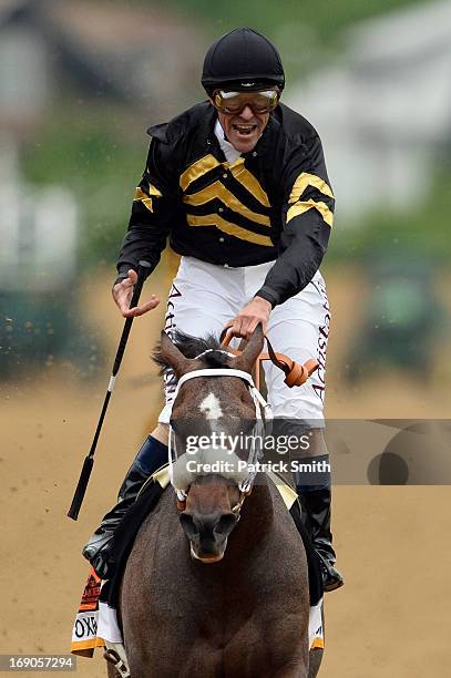 Gary Stevens celebrates atop of Oxbow after crossing the finish line to win the 138th running of the Preakness Stakes at Pimlico Race Course on May...