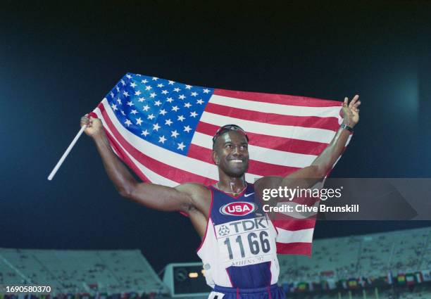 Allen Johnson from the United States celebrates with the Stars and Stripes flag after winning the gold medal in the Men's 110 Metres Hurdles race at...